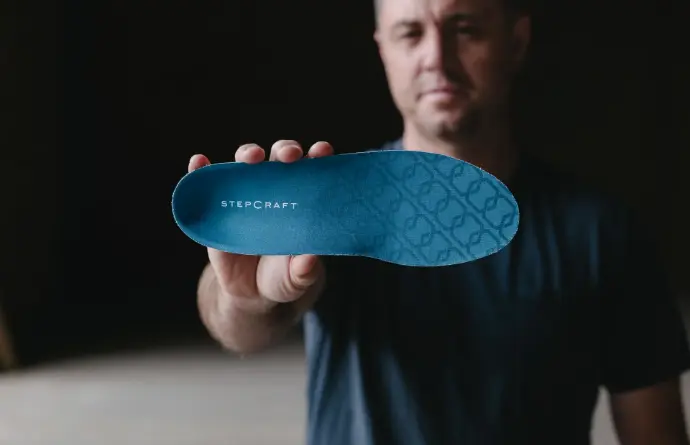 Man holding StepCraft Mid insoles
